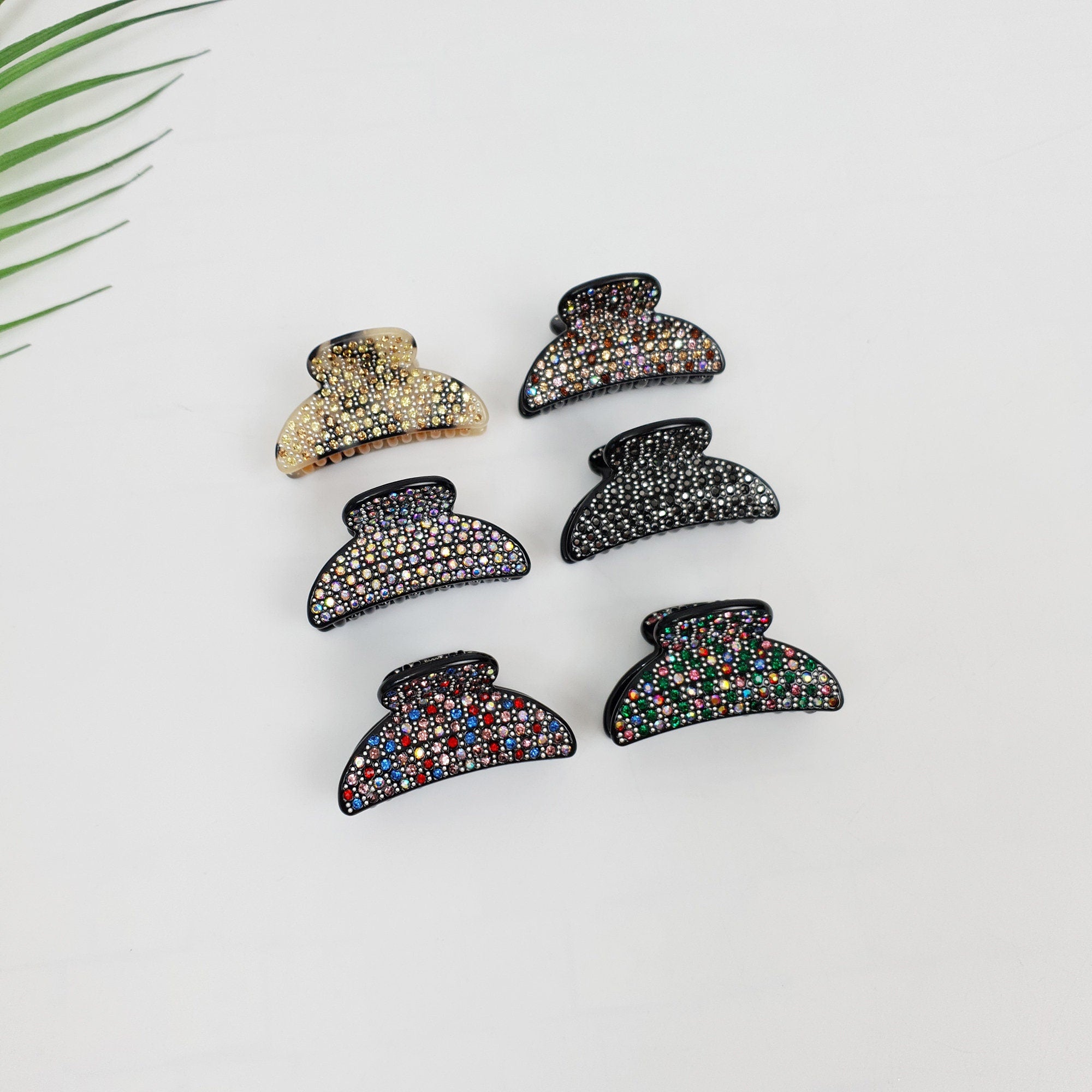 Small half-moon cellulose acetate hair claw clip embellished with sparkling cubic zirconia crystals. 1.8 inch mini jaw clip with double inner teeth for secure grip.