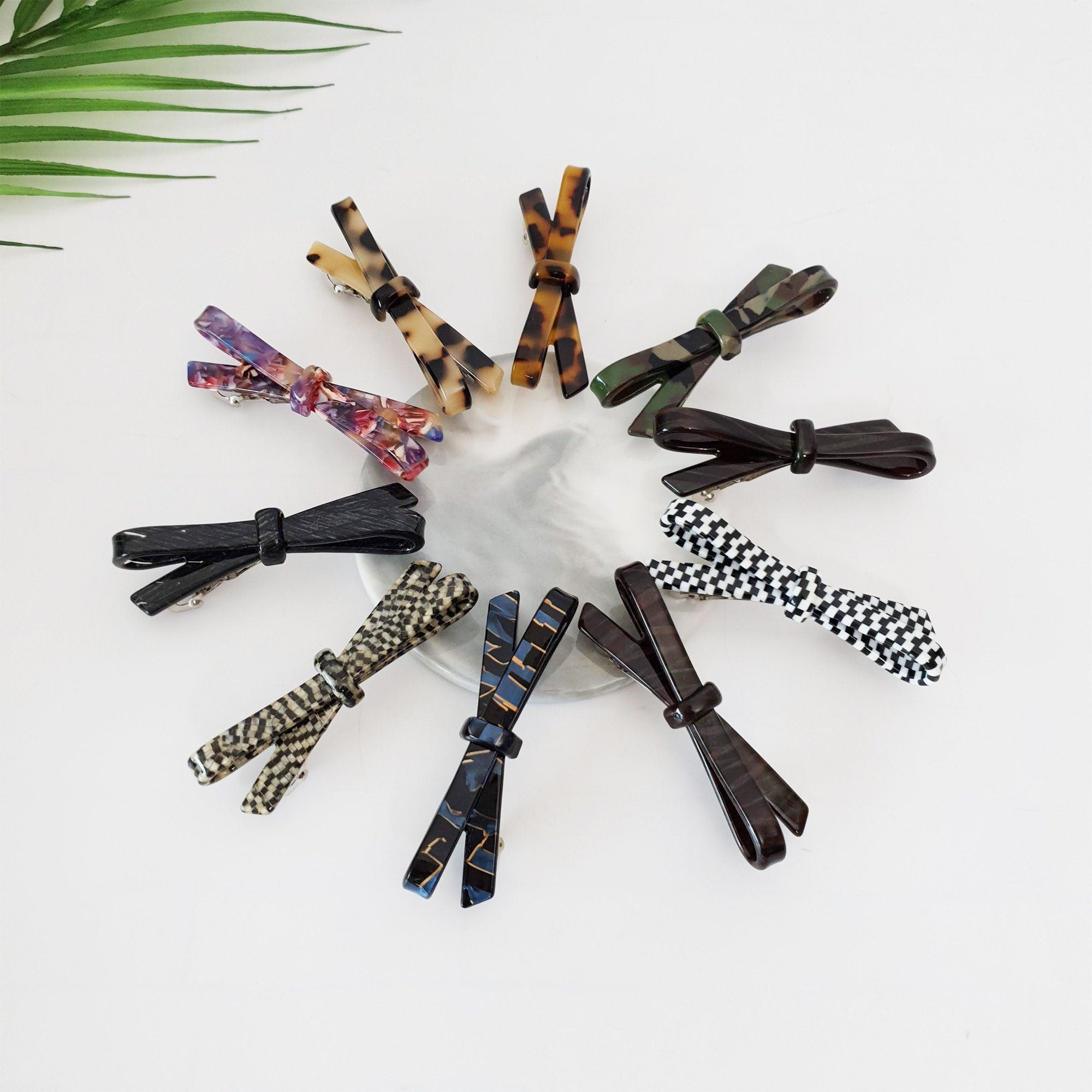 Cellulose acetate bow hair barrette available in tortoise shell, marble, and checkered patterns. Small 2.8 inch automatic clip for bangs and side hair styling.