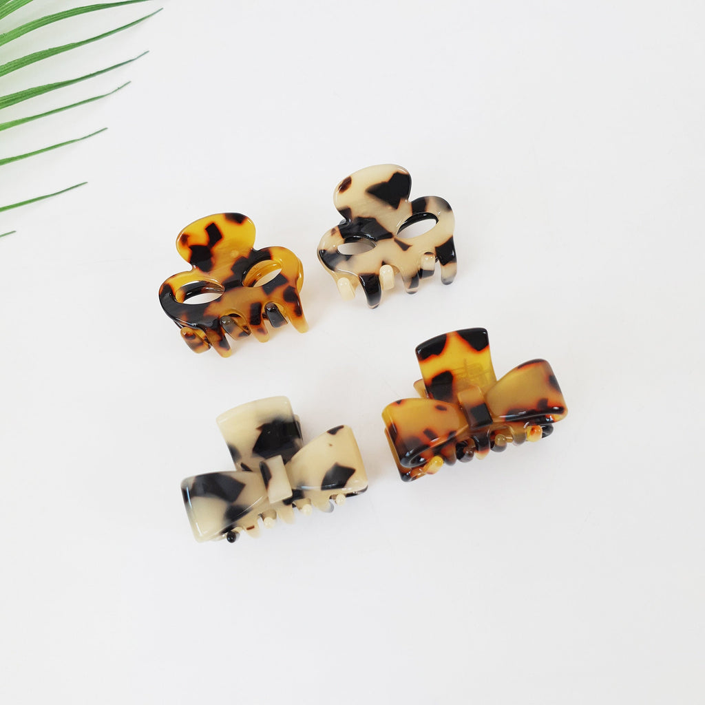 Cellulose acetate mini hair claw clips in skull and bow shapes. Small tortoise shell jaw clips for bangs and half up hairstyles.