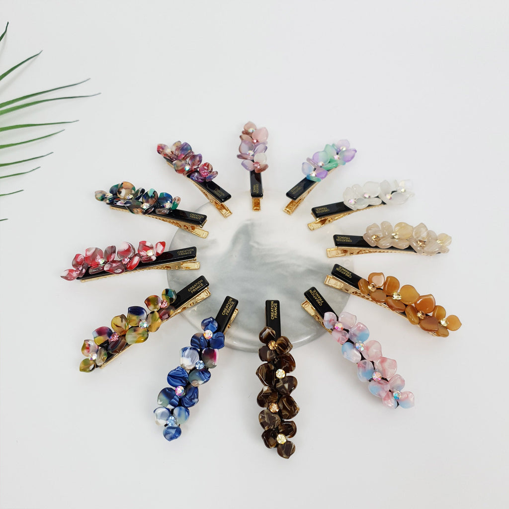 Cellulose acetate flower hair clip with rhinestone center. 2.8 inch alligator clip for side hair and bangs in pastel colors.