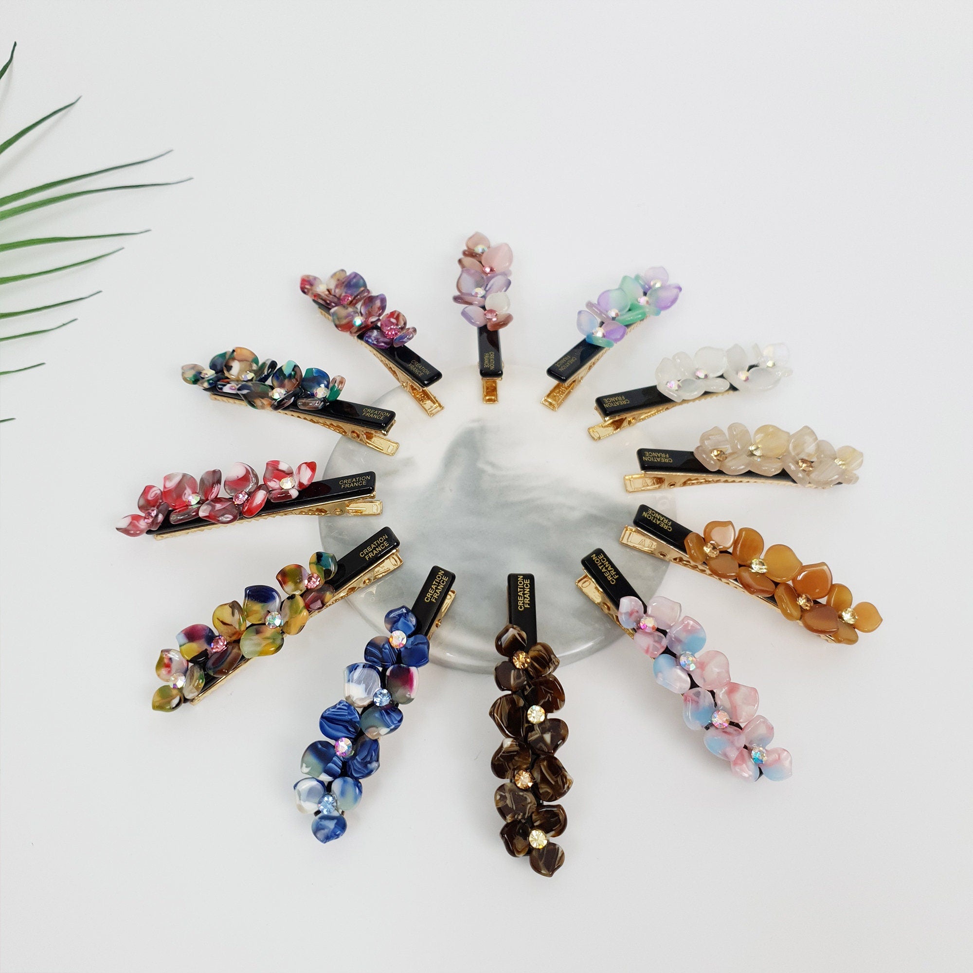 Cellulose acetate flower hair clip with rhinestone center. 2.8 inch alligator clip for side hair and bangs in pastel colors.