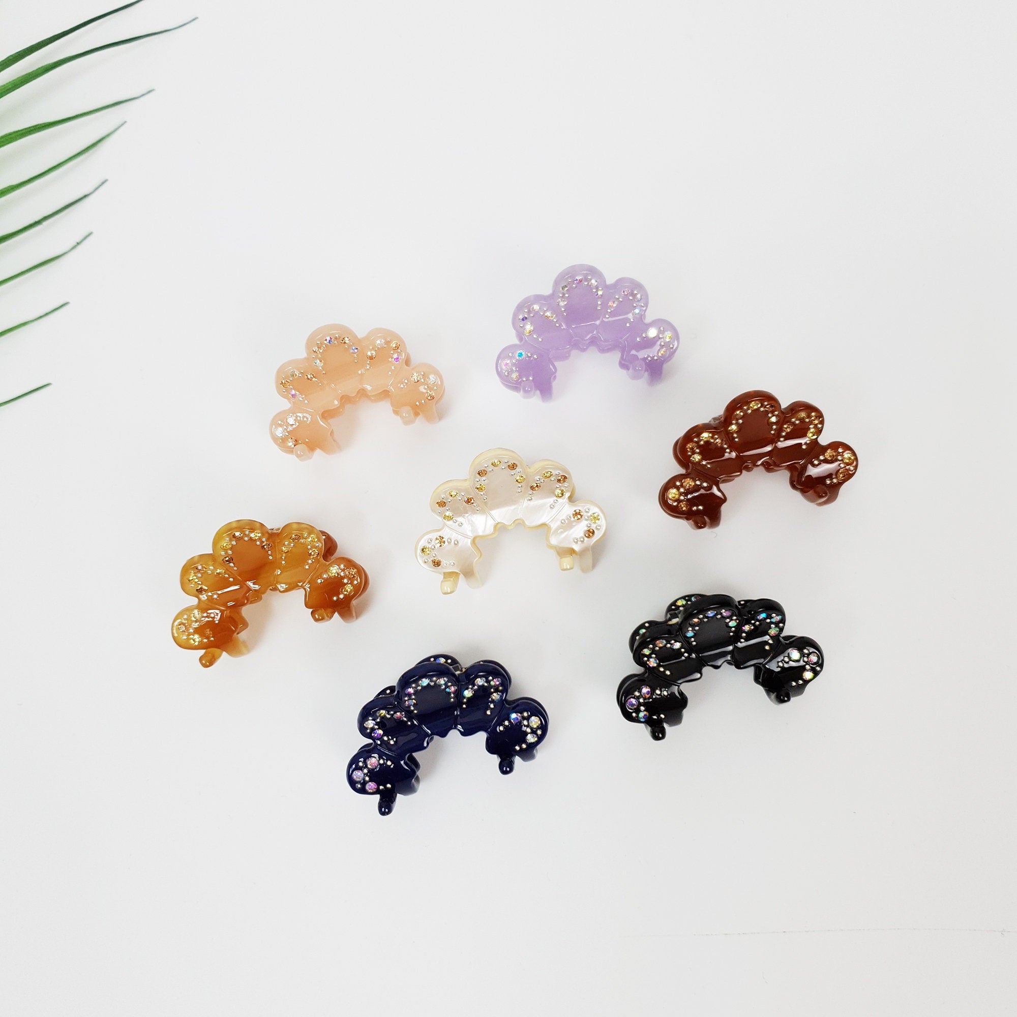 Cellulose acetate mini hair claw clip shaped like a crown with rhinestone accents. Small 1.5 inch jaw clip in pastel and dark tones for side hair styling.
