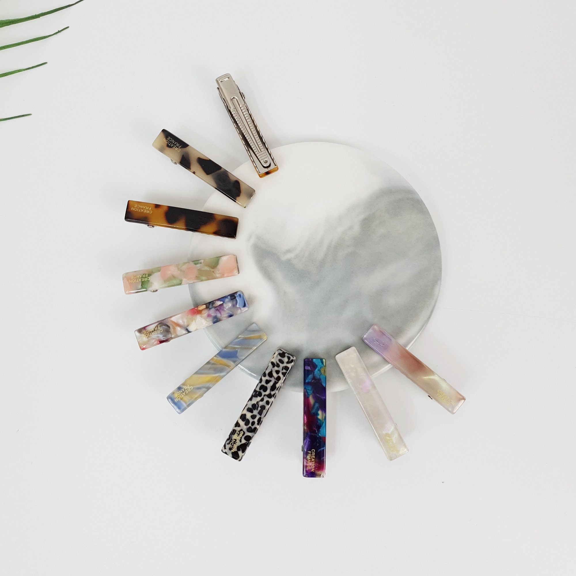 Small cellulose acetate hair clips in tortoise shell and leopard patterns. Mini rectangular alligator clips for styling bangs and side hair. Cute minimalist hair accessory for women.