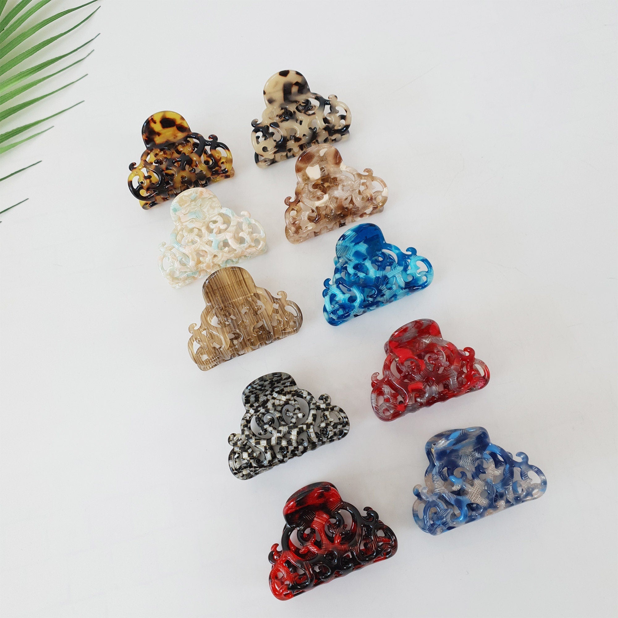 Cellulose acetate small hair claw with ornate filigree cutout design. Vintage style tortoise shell and marble pattern jaw clip for half up hairstyles.