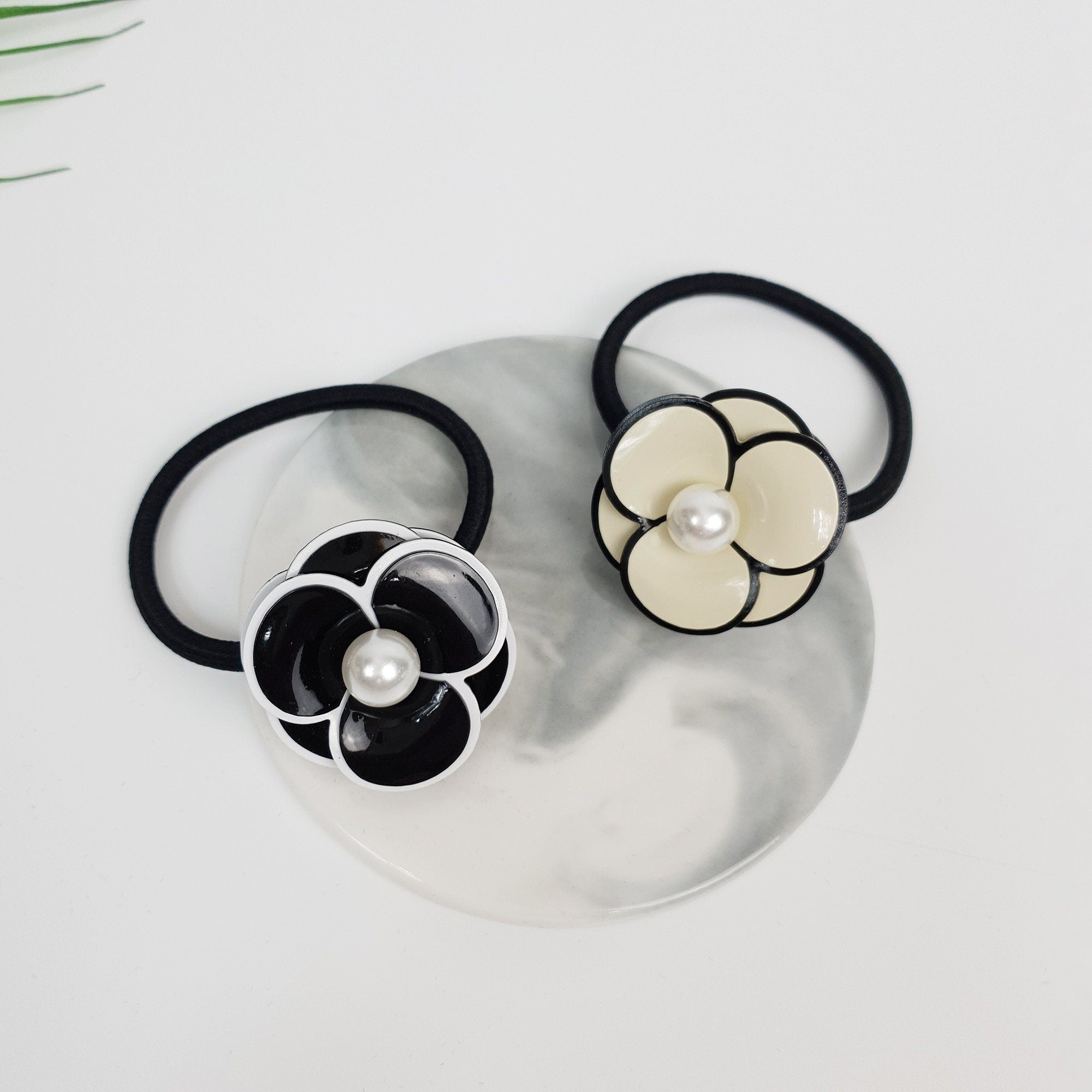 Glossy cellulose acetate pansy flower hair tie with pearl center in black and beige. 1.4 inch floral ponytail holder. Elegant Korean fashion accessory for women birthday gift.