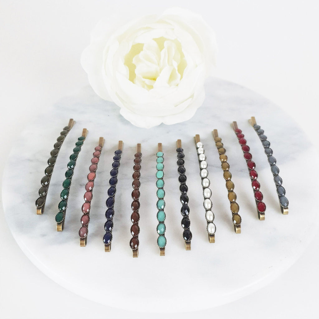 Long vintage style antique brass bobby pin featuring a row of small round acetate stones. 3.1 inch retro hair slide for women and side hair styling.