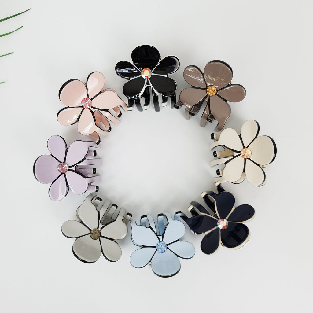 Small cellulose acetate hair claw clips in flower shape with rhinestone center. Pastel color mini jaw clips for half up hairstyles.