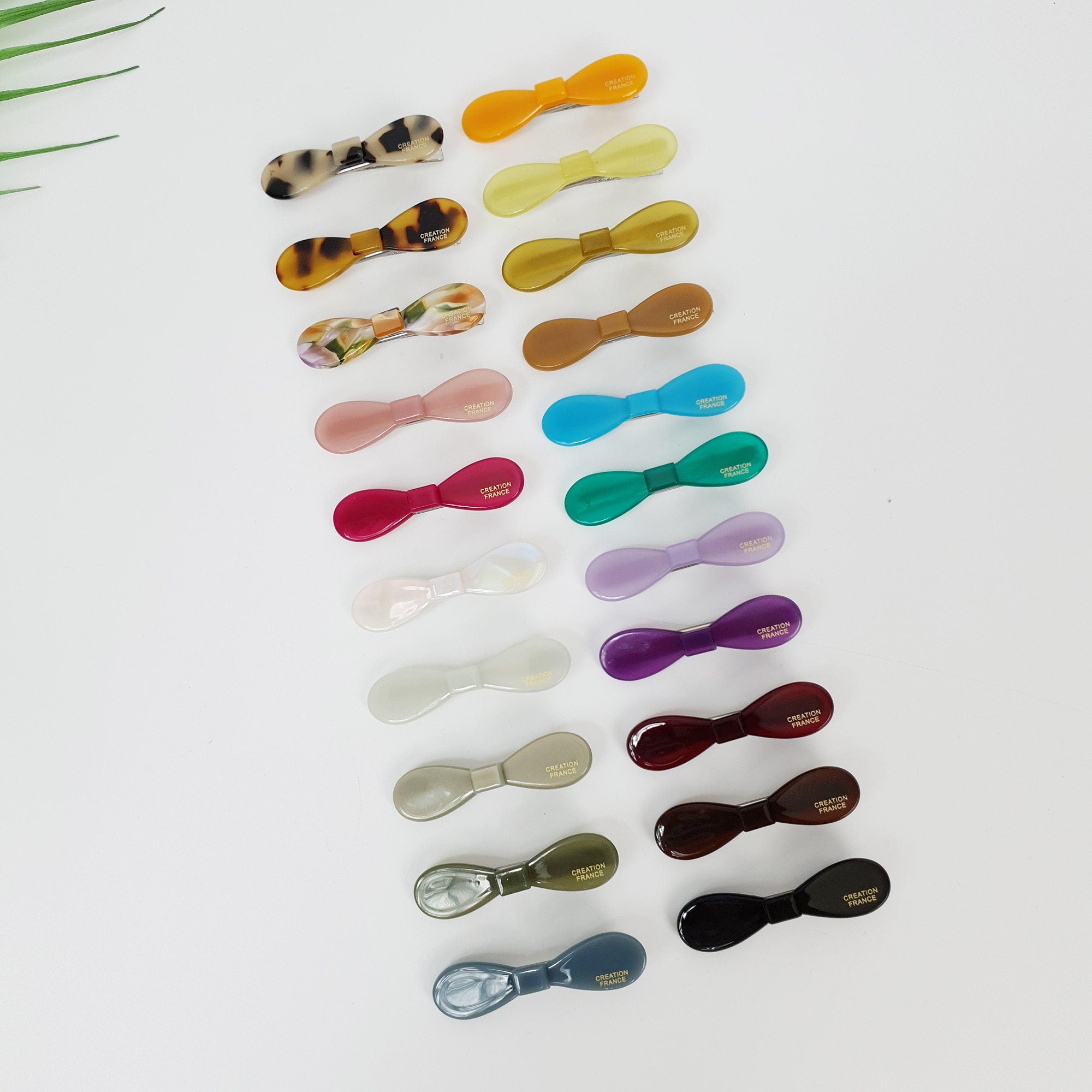 Glossy cellulose acetate bow hair clip in tortoise shell and solid colors, durable alligator clasp for side bangs, preppy minimalist hair accessory for daily styling.