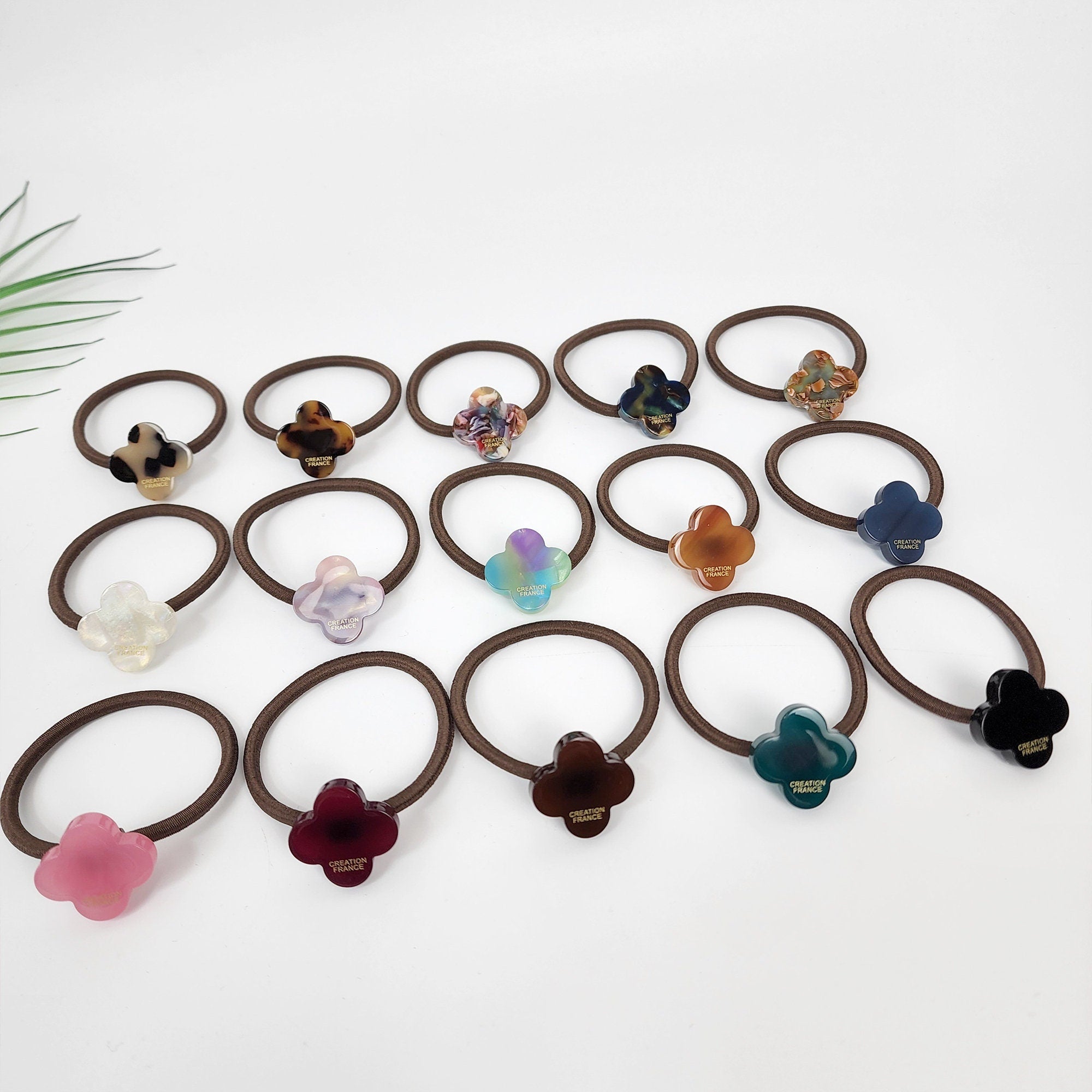 Glossy cellulose acetate four leaf clover hair tie in tortoise and pastel colors. 1 inch lucky charm ponytail holder. Preppy Korean fashion accessory for women birthday gift.
