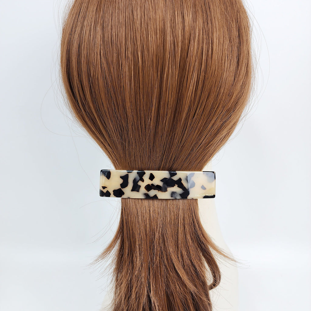Cellulose acetate rectangular hair barrette in tortoise shell pattern for women styling a low ponytail or half updo.
