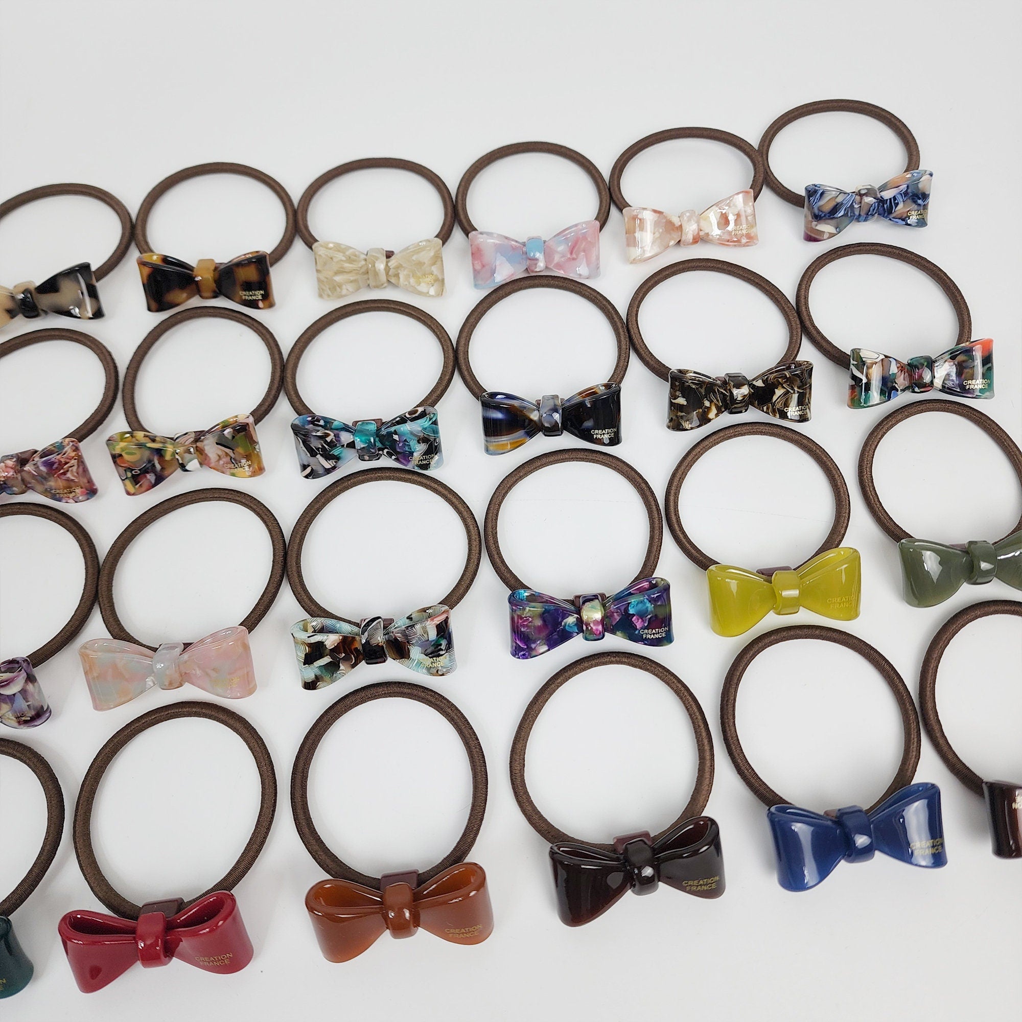 Glossy cellulose acetate mini ribbon hair tie in tortoise shell and marble colors. Small 1.6 inch bow ponytail holder. Preppy Korean fashion accessory for women birthday gift.