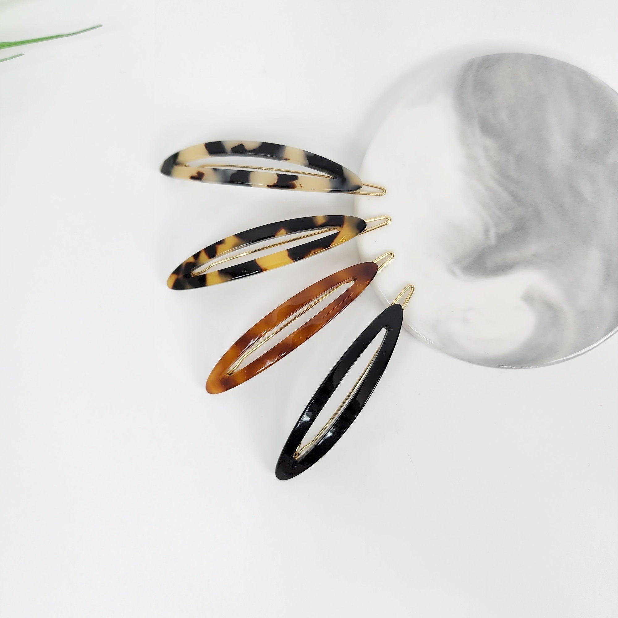 Cellulose acetate open oval hair clips in tortoise shell and black, geometric cutout snap barrette for bangs and side hair styling.