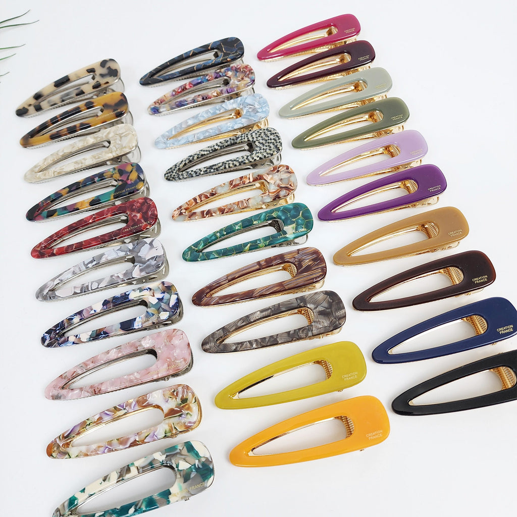 Cellulose acetate triangle alligator hair clips in tortoise shell and marble patterns. 3.1 inch geometric hollow barrette for women's side bangs. Minimalist Korean fashion accessory.