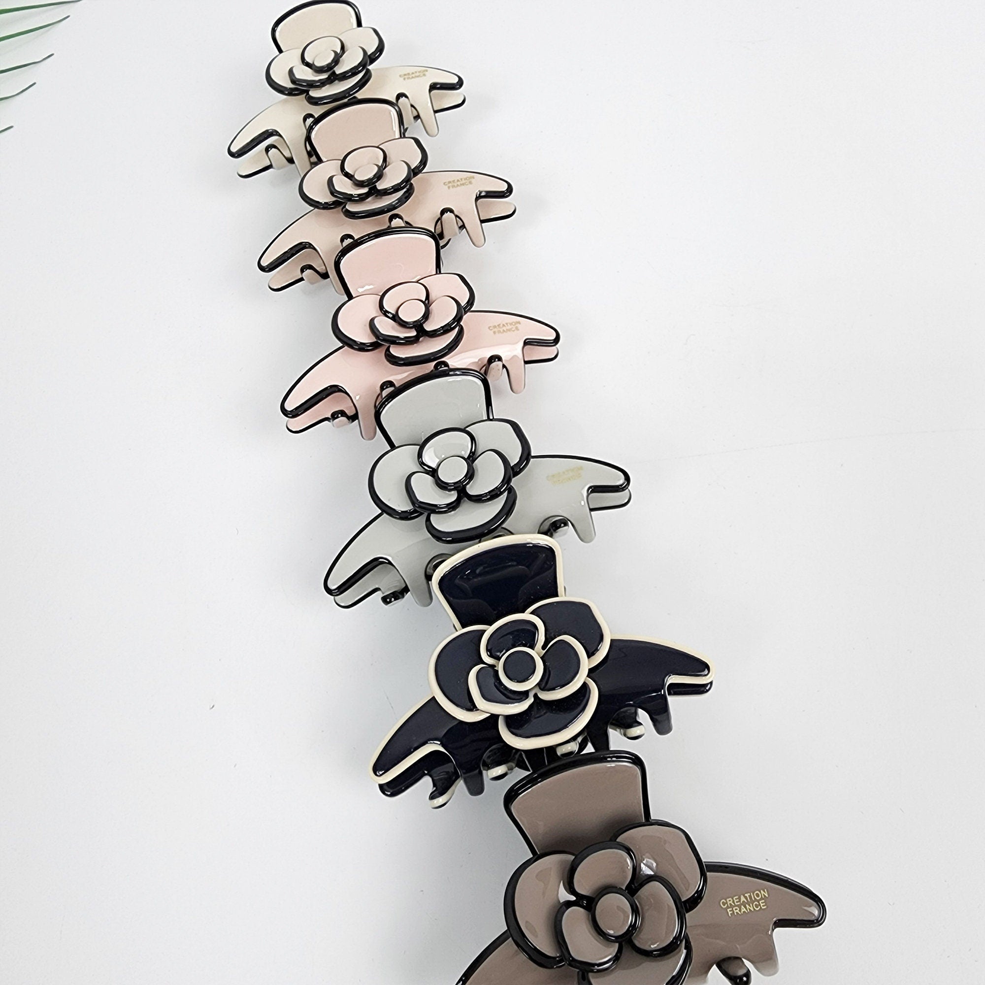 Cellulose acetate camellia flower hair claw clip in pastel and classic colors, elegant floral half-up hair accessory.