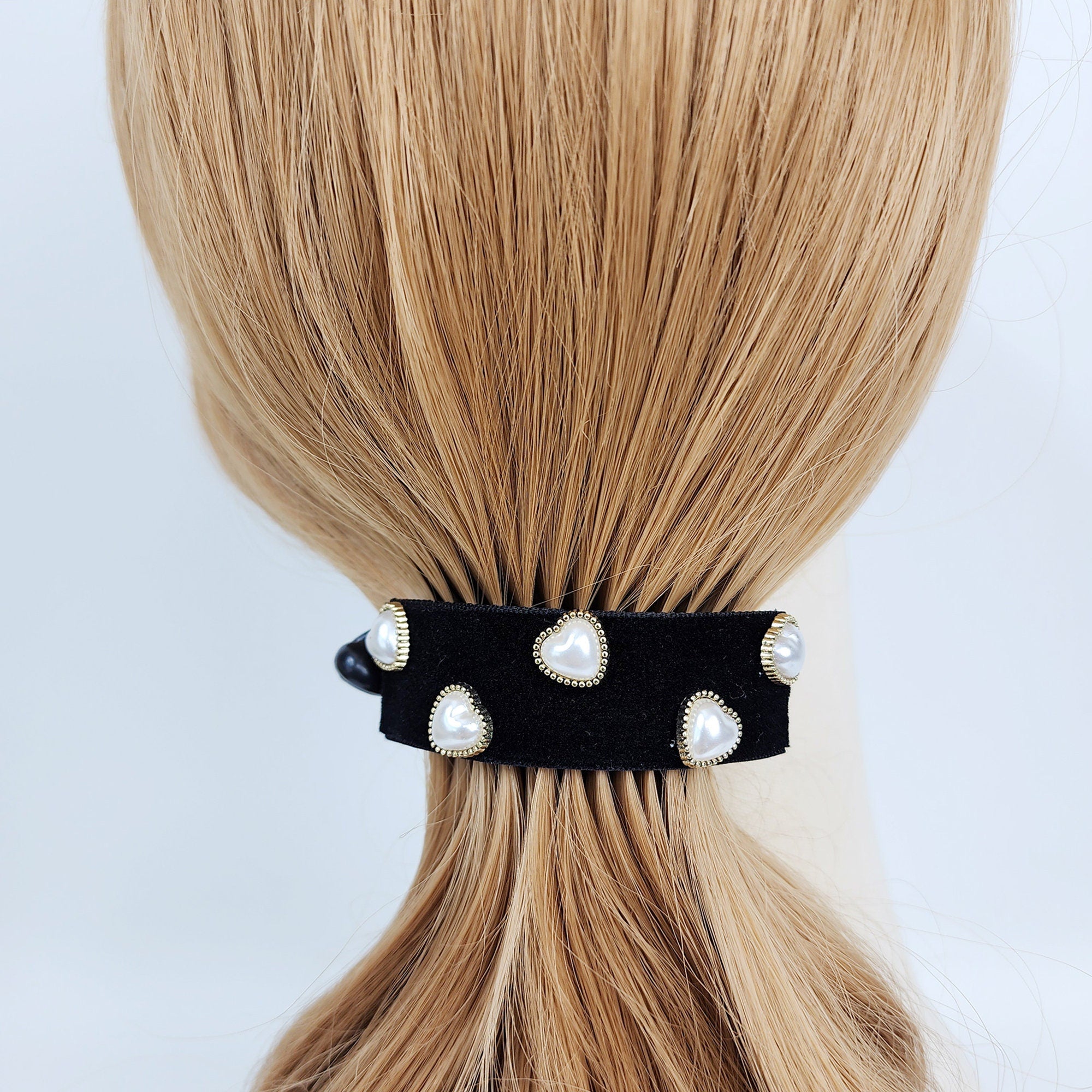 Black velvet banana hair clip with heart shaped pearl and rhinestone accents. 3 inch curved ponytail holder for women creating volume or half up hairstyle. Black velvet hair tie with gold accents and white pearl heart embellishments