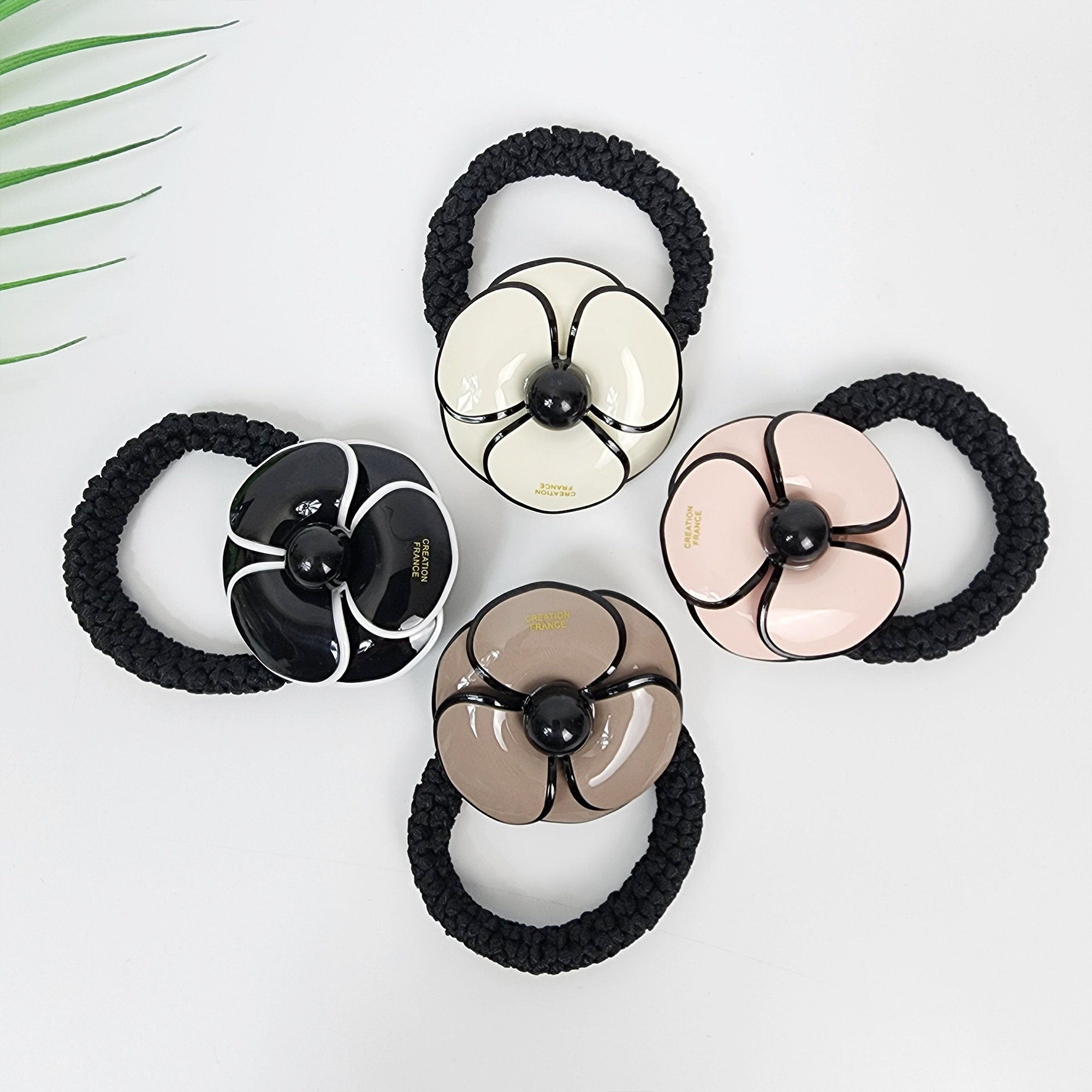 Glossy cellulose acetate flower hair tie with black outline in pink white beige and black. Thick elastic ponytail holder 2 inch floral charm for women and girls birthday gift. Mod style Korean fashion accessory.