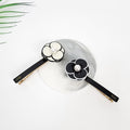 Elegant acetate pansy flower hair clip with pearl center, black and white floral side barrette for women, sturdy Korean style hair accessory for birthday gift. Two black and white flower hair clips with a pearl in the center of each flower. The clips are on a white marble surface. The text on the clips reads 'CREATION FRANCE'.