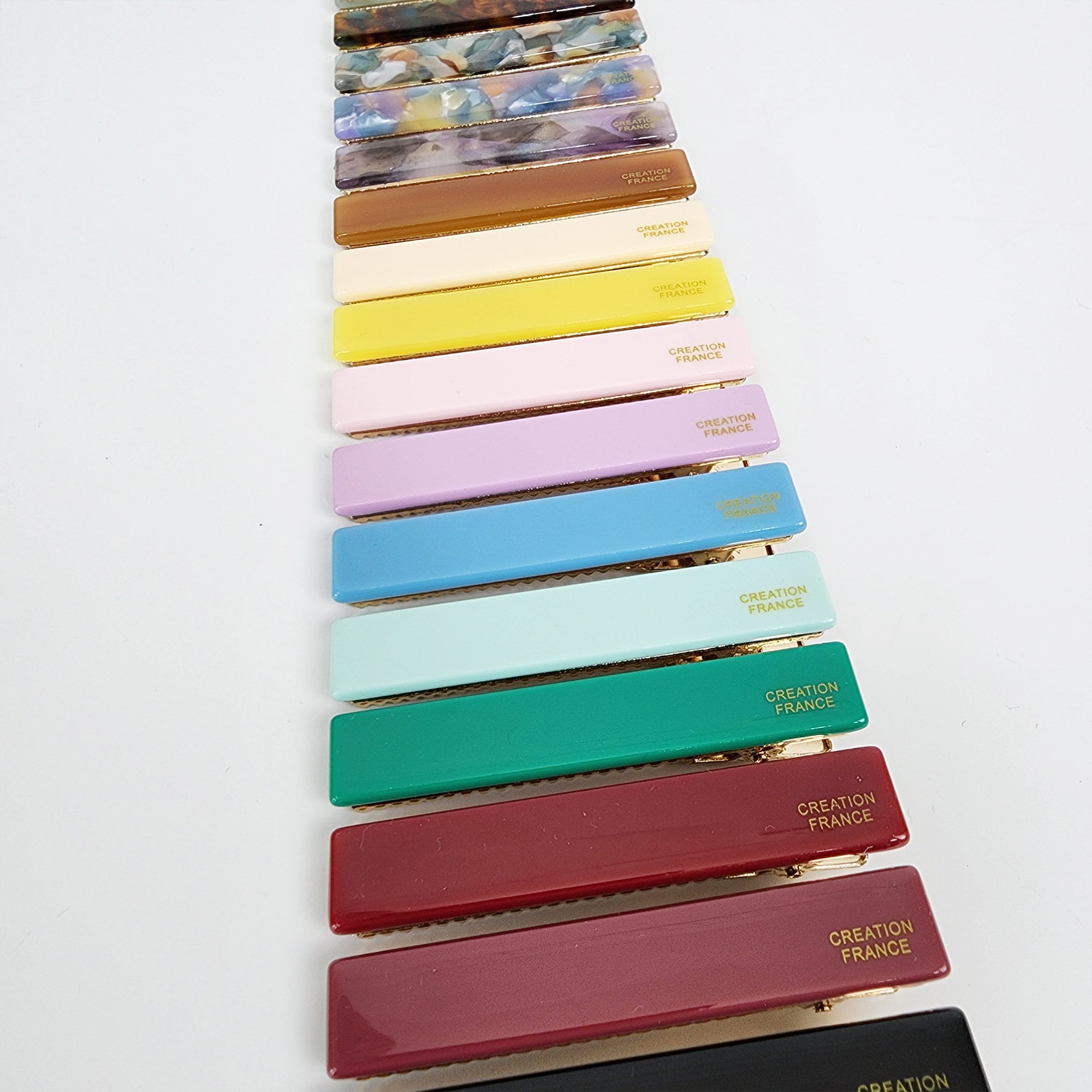 Cellulose acetate hair barrette in solid beige simple rectangle slide clip for side bangs A set of 14 hair clips in various colors including black, red, green, blue, pink, yellow, and brown. Each clip has a gold metal bar with the text 'CREATION FRANCE' printed on it.
