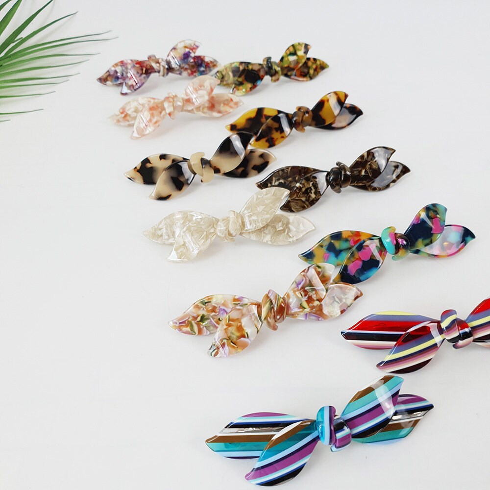 Cellulose acetate double wave ribbon bow barrette. 3.7 inch automatic hair clip in tortoise and marble patterns for side bangs styling.