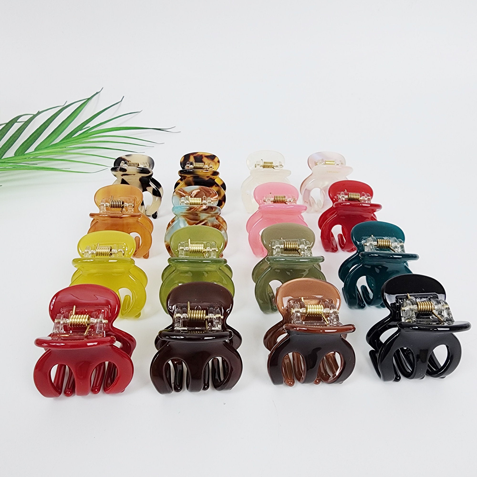 Cellulose acetate small hair claw clip in tortoise shell and solids, round mini jaw clip for half up hairstyles, cute Korean hair accessories. A collection of 15 plastic hair claw clips in various colors including red, green, brown, yellow, black, white, and tortoise shell. The clips are arranged in three rows of five.