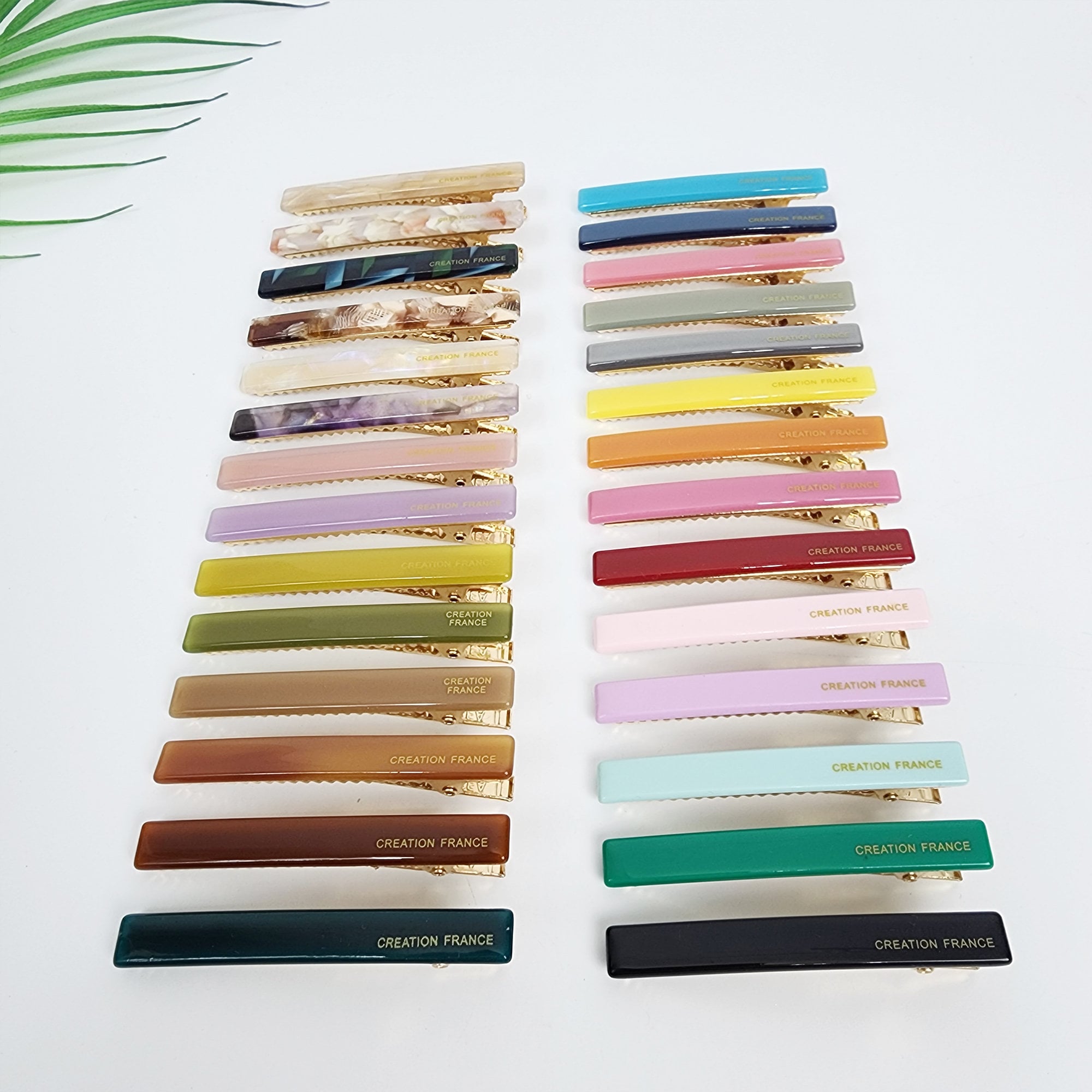 Slim rectangular cellulose acetate alligator clip in vivid and pastel colors. Minimalist stick hair slide for side bangs holding, glossy simple hair accessory. A set of 18 hair clips in various colors, including teal, pink, gray, yellow, orange, purple, green, brown, and black. Each clip has a gold metal clasp and the words 'CREATION FRANCE' printed on the bottom.