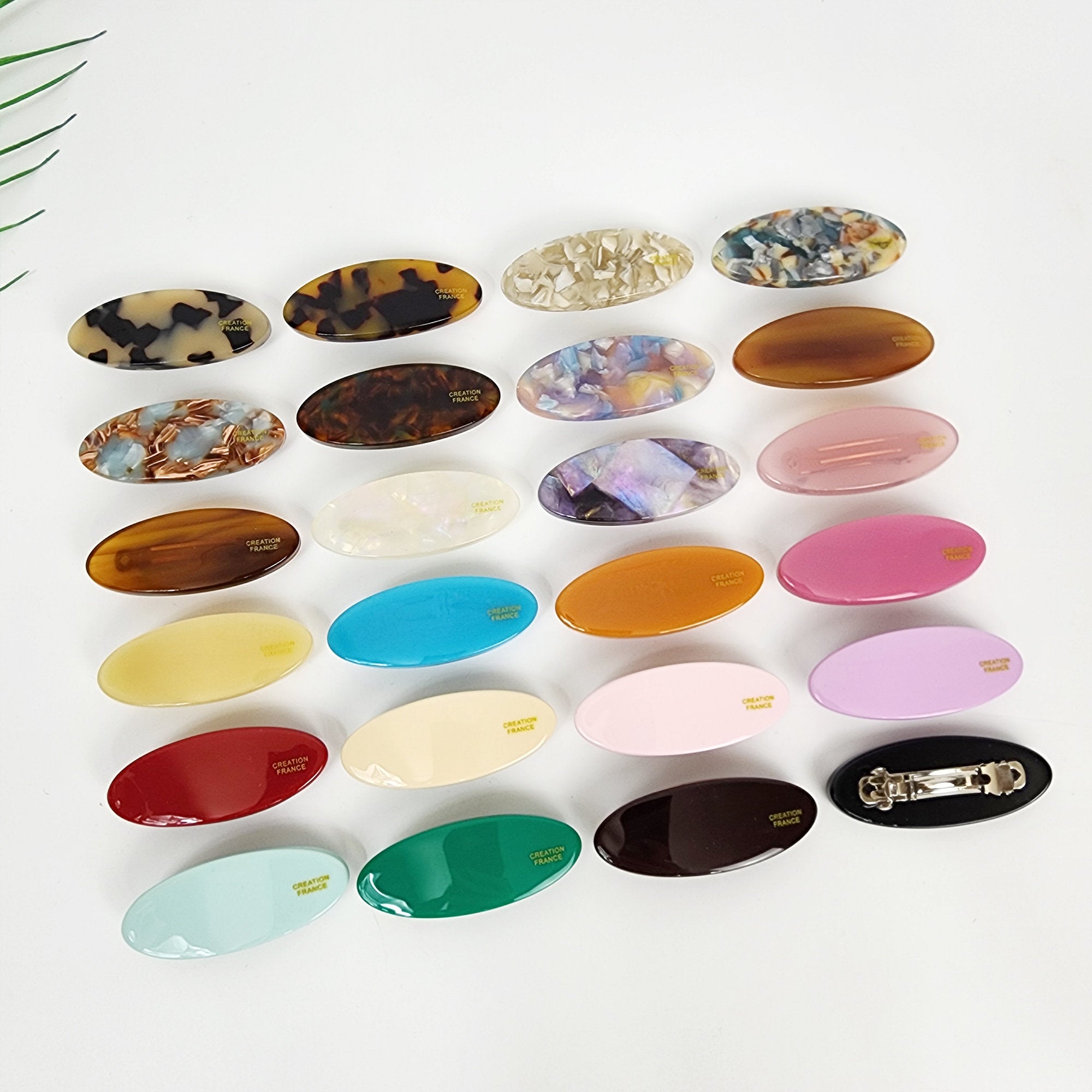 Small oval shaped cellulose acetate automatic hair clip in pink. Mini pastel hair barrette for side bangs styling, cute minimalist accessory for girls.