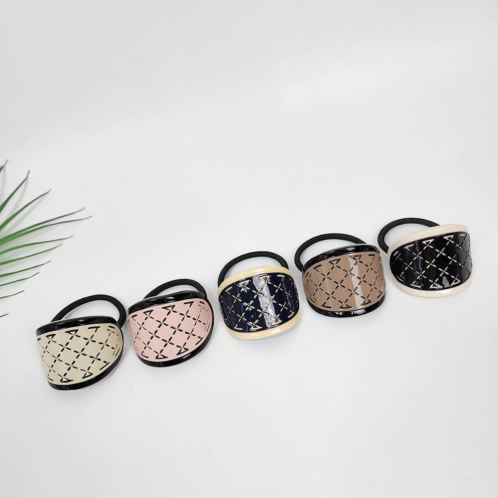 Cellulose acetate quilted hair tie with gold accents, curved ponytail cuff holder, elegant geometric accessory for birthday gifts. Five hair scrunchies with black elastic bands and decorative plastic covers. The covers are in different colors: beige, pink, navy blue, brown, and white. Each cover has a geometric pattern of small squares with a black outline.