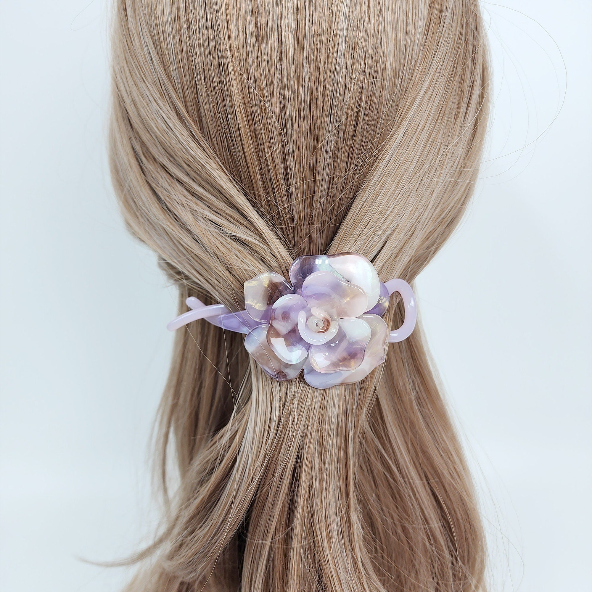 Cellulose acetate banana clip featuring a voluminous marble flower design. 4.3 inch hair accessory perfect for half-up styles and securing fine hair in pink and blue colors.