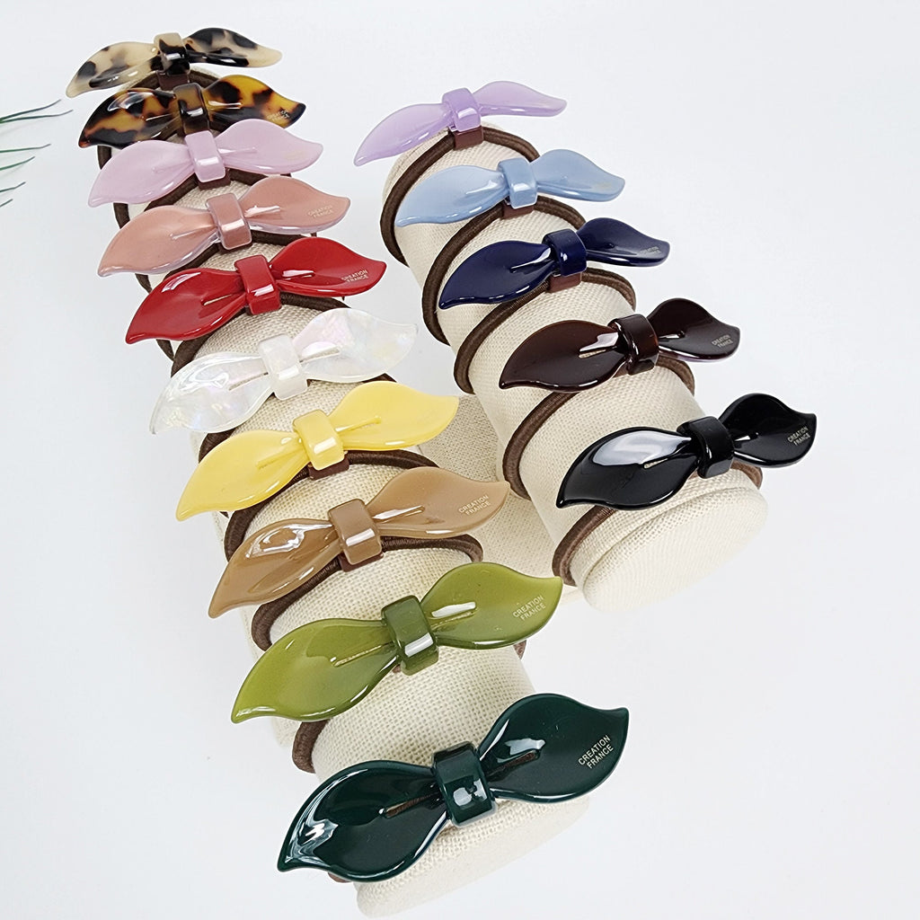 Cellulose Acetate bow hair tie in tortoise shell and pastel colors minimalist lip shaped ribbon ponytail holder for birthday gift. A collection of 14 hair scrunchies with bow-shaped accents in various colors, including brown, pink, red, yellow, green, blue, and black. Each scrunchie has a small tag that reads 'Creation France'.