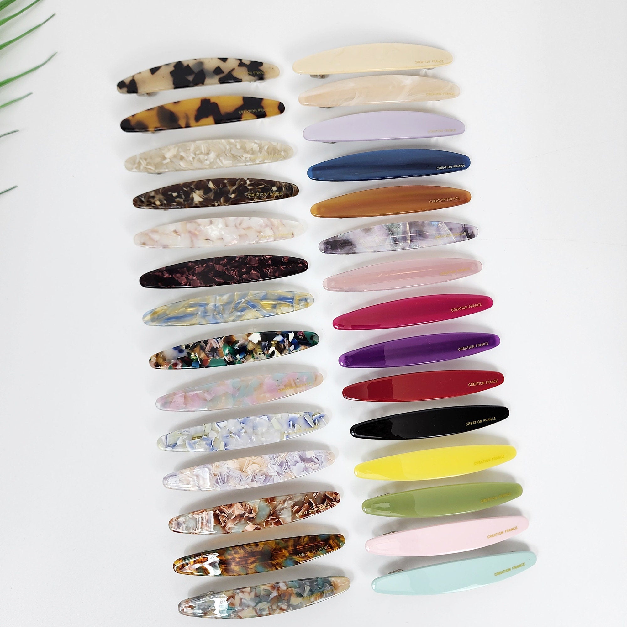 Cellulose acetate oval hair barrette in tortoise shell and marble patterns. Minimalist side hair clip for women featuring a secure automatic clasp mechanism.