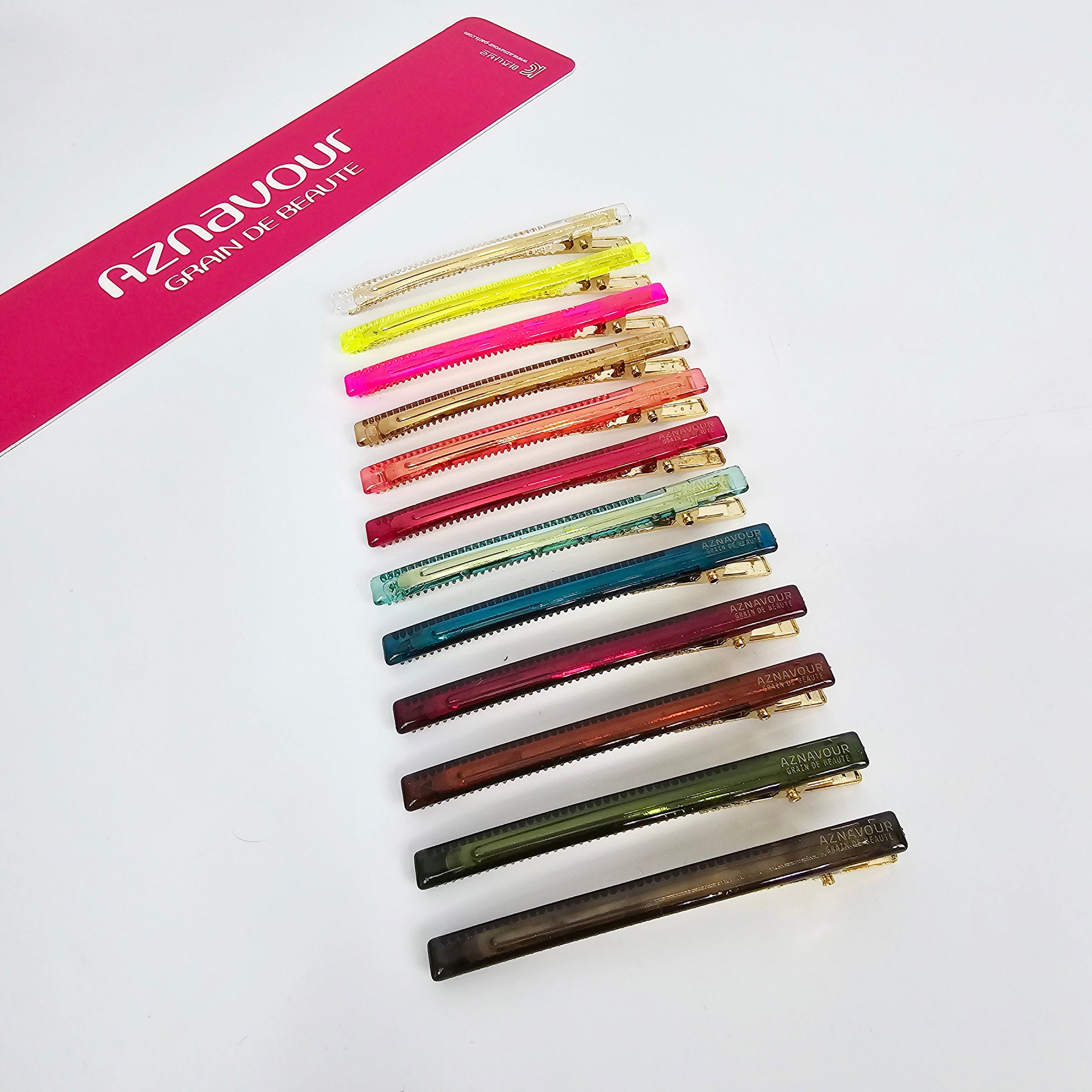 Slim cellulose acetate alligator clip in neon and clear colors. 3.1 inch long skinny barrette with gold beak mechanism for securing side bangs and flyaways.