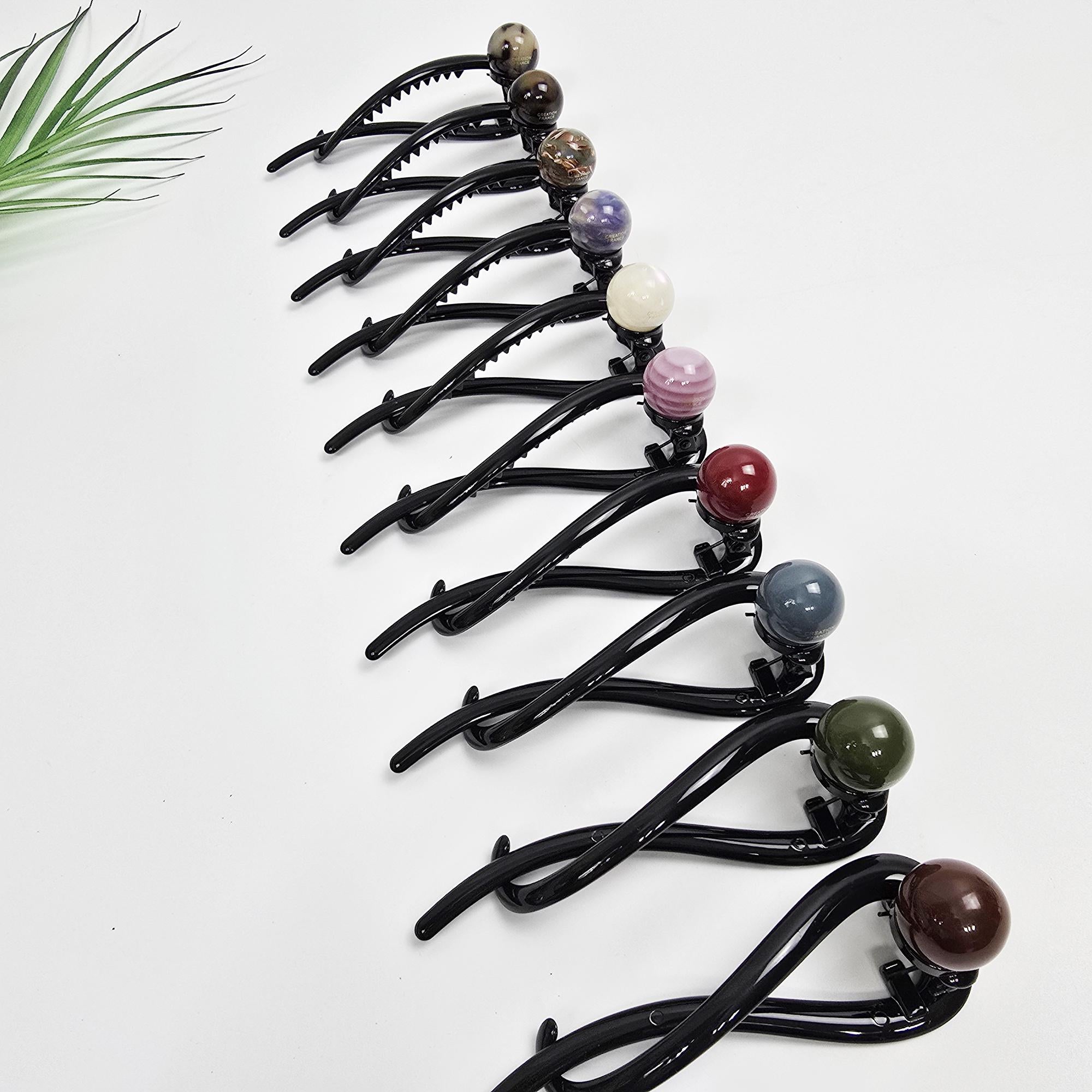 Cellulose acetate twist banana hair clip with a candy ball accent. 4.3 inch updo holder featuring an infinity loop design. Stylish hair accessory for thick hair.