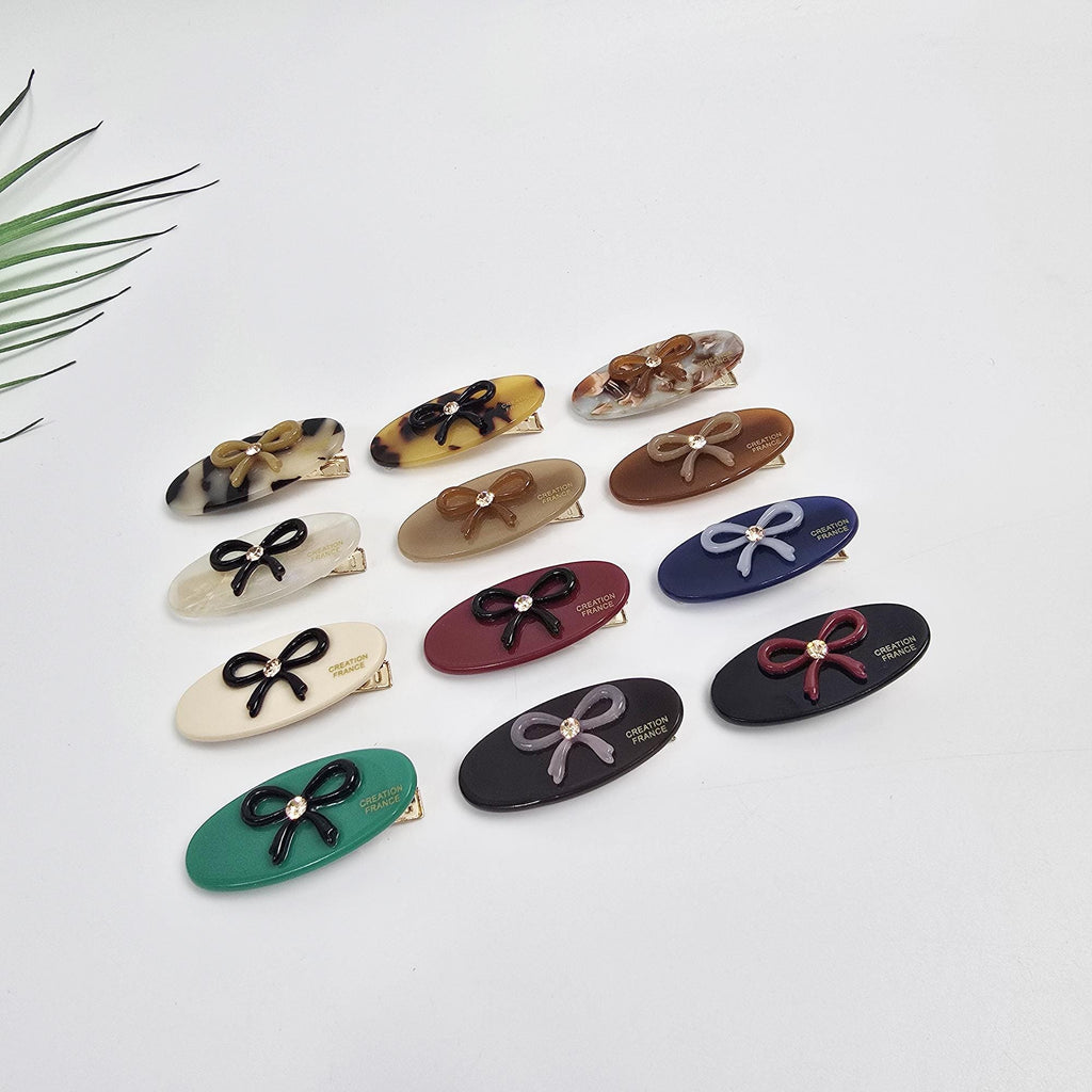 Cellulose acetate oval hair clip with tiny bow accent. 1.7 inch flat alligator barrette in tortoise shell and pastel colors. Cute hair accessory for toddler girls side bangs.