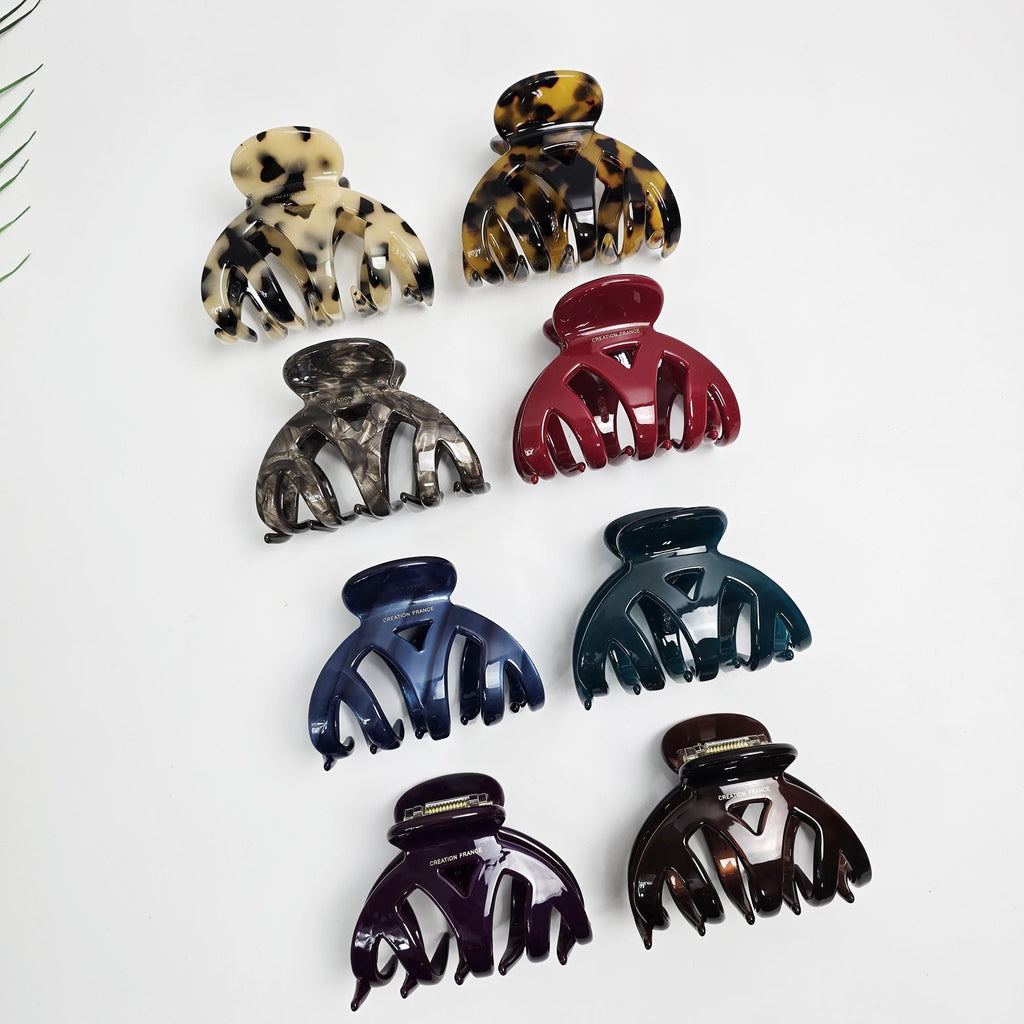 Medium cellulose acetate hair claw clip featuring a curved bridge design, available in tortoise shell and solid colors for secure half-up styling.
