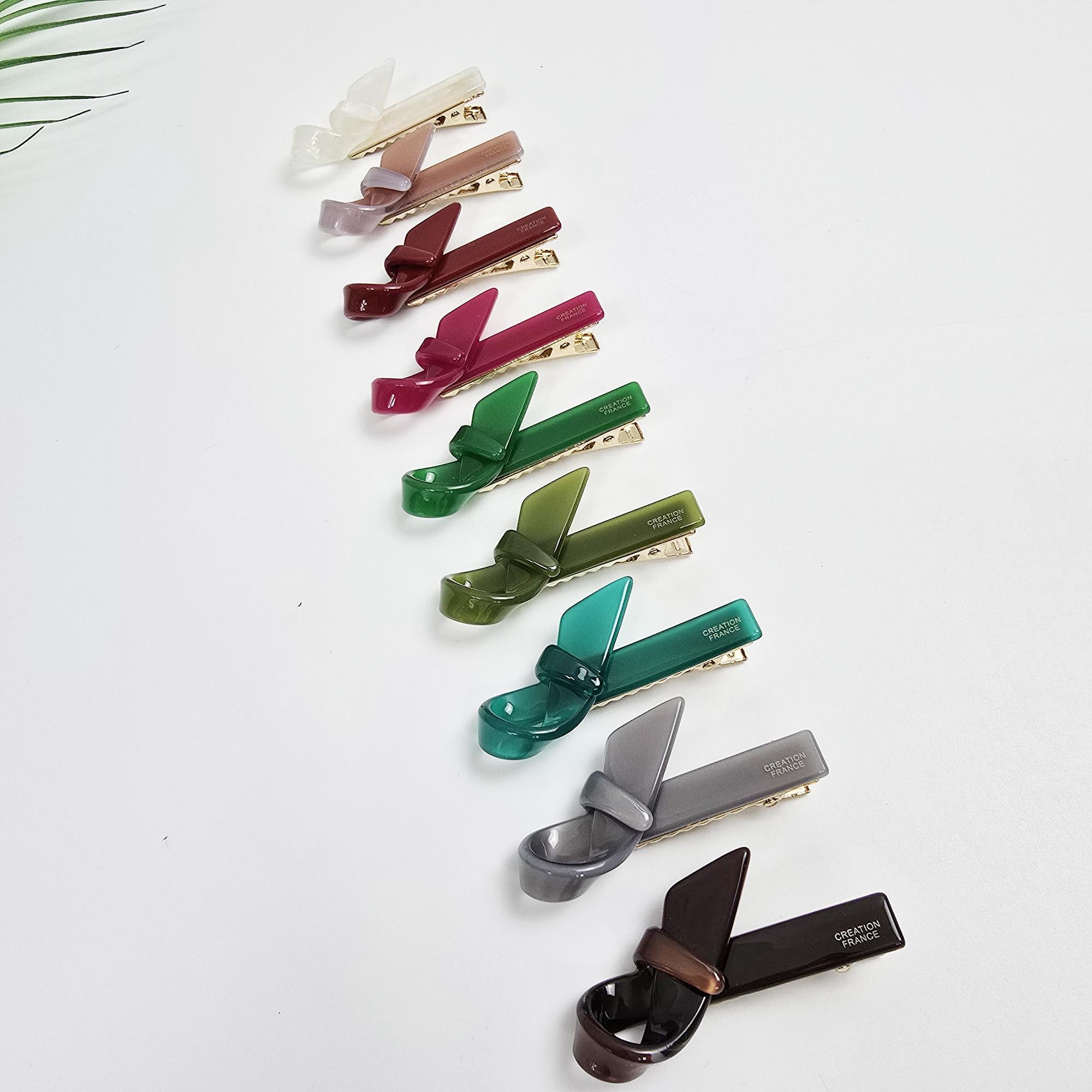 Cellulose acetate alligator hair clip featuring a unique knotted scarf ribbon design. 2.2 inch small barrette available in pink, green, and tortoise shell. Perfect for holding side bangs.