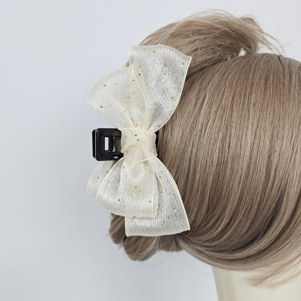 Large sheer chiffon bow hair claw clip with gold dots. 5.1 inch tulle ribbon jaw clamp for women updos and bridal styles. A large white bow with gold glitter accents attached to a black hair clip.