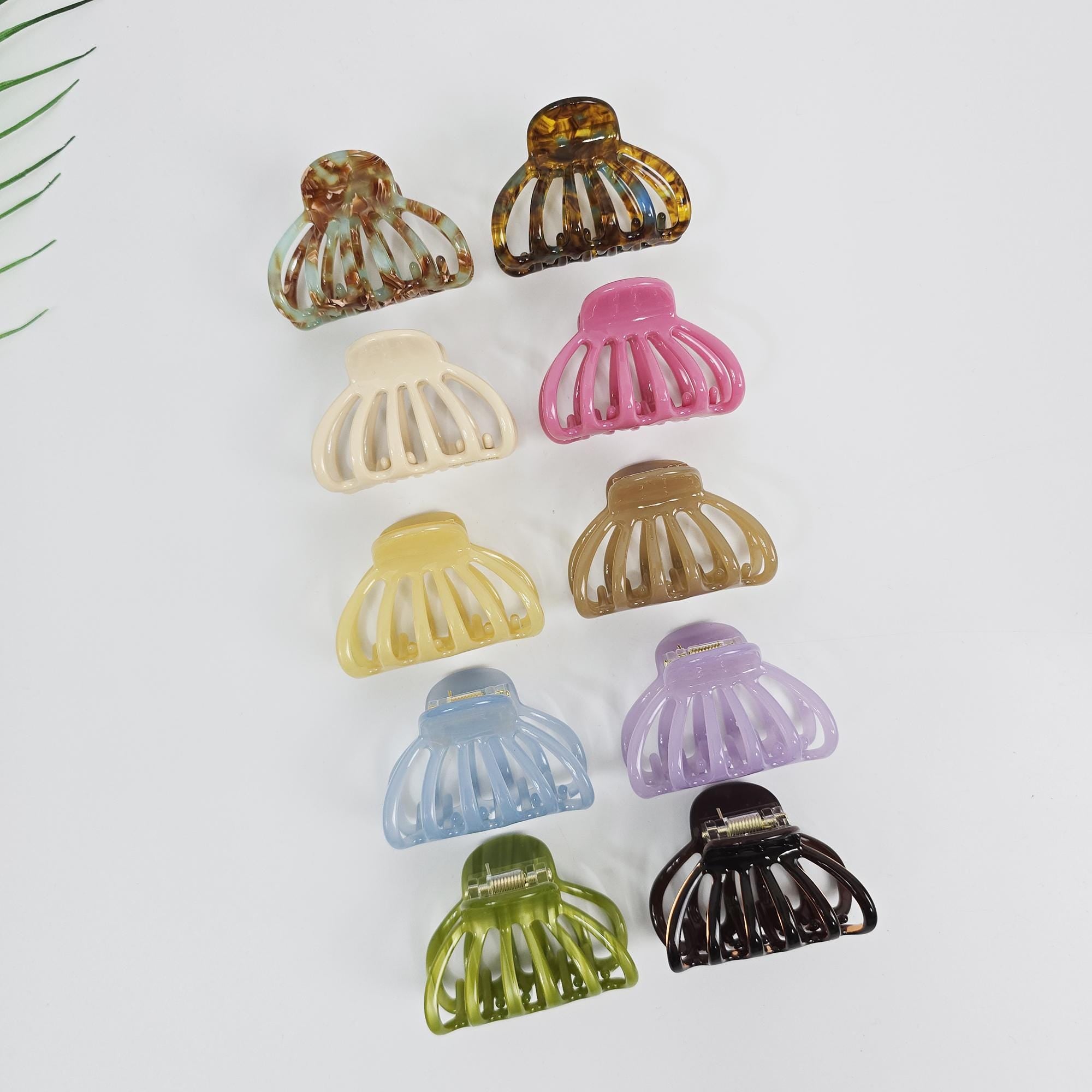 Cellulose acetate round hair claw clip in pastel and tortoise shell colors. Small 2.2 inch half-up jaw clamp for women and girls. Ten plastic hair clips in various colors including brown, beige, pink, light brown, light blue, purple, and green. The clips are all the same shape and have a curved design with five prongs.