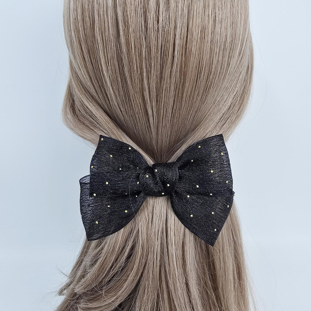 Sheer chiffon big bow hair clip with gold dots. 5.5 inch tulle ribbon barrette for women half up hairstyle. A black bow with gold glitter dots. The bow is made of a soft, sheer fabric and is tied in a simple knot.