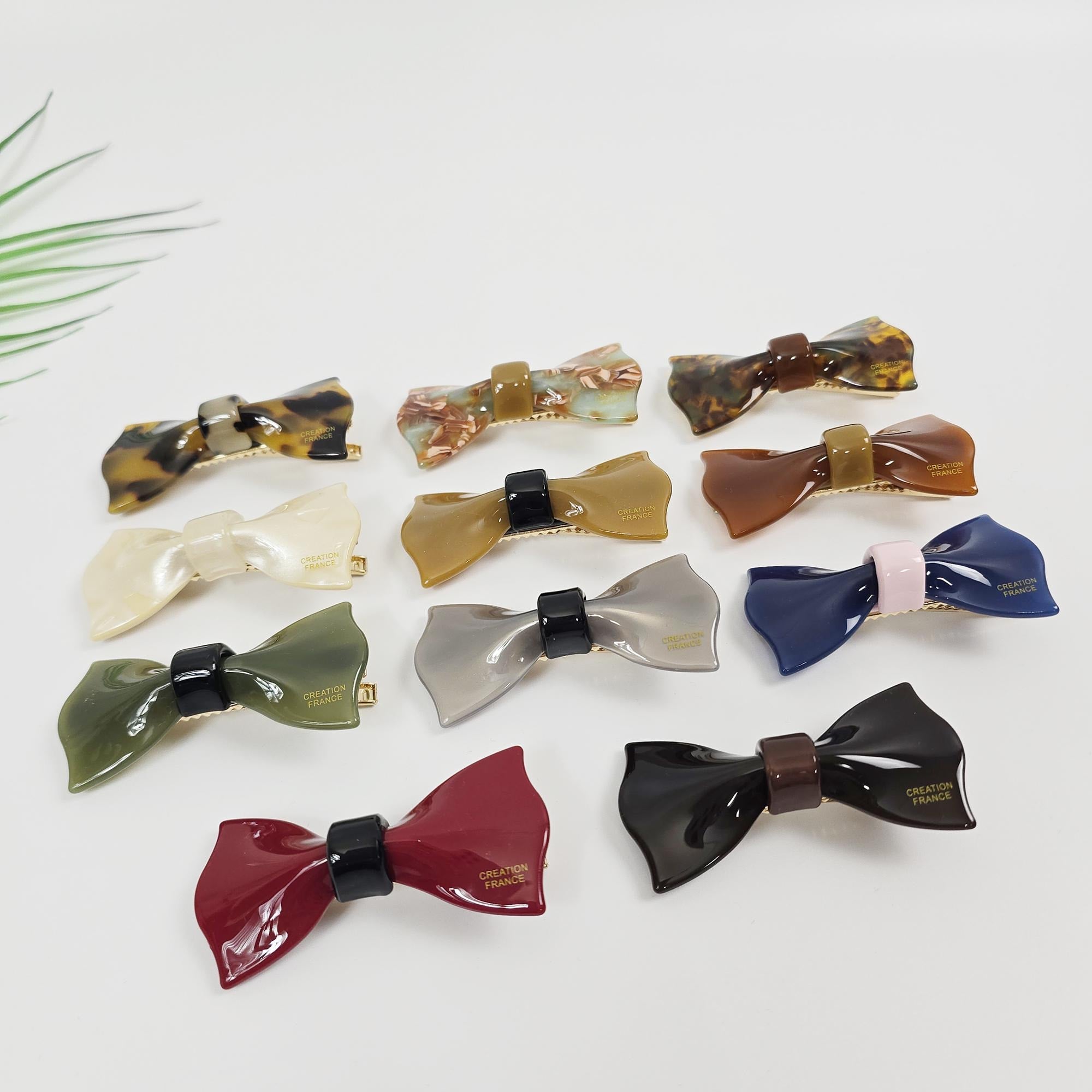 Glossy cellulose acetate ribbon hair clip with gold alligator clasp. Small bow barrette for girls and women in tortoise shell and solid colors.